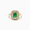 The 14K Yellow Gold Emerald and Diamond Double Halo Ring features an emerald-cut green gemstone at the center, framed by two rows of round and baguette diamonds in a rectangular halo setting.
