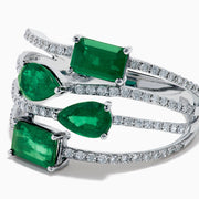 The 14K White Gold Emerald and Diamond Open Multi Row Ring showcases three bands set with diamonds and accented by large rectangular, square, and teardrop-shaped emeralds for a dazzling effect.