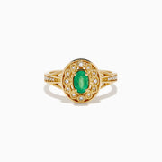 The 14K Yellow Gold Emerald and Diamond Filigree Halo Ring showcases a central oval green emerald, surrounded by a sparkling diamond halo and diamonds set along the split band.