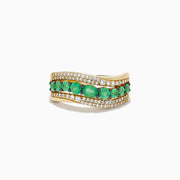 The 14K Yellow Gold Emerald and Diamond Wave Band features a central row of green emeralds bordered by two wavy rows of sparkling white diamonds in an elegant overlapping design.