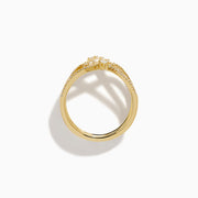 The D'Oro 14K Yellow Gold Interlaced Crisscross Diamond Ring features overlapping bands adorned with small diamonds and baguette-cut stones in a striking crisscross pattern, displayed on a white background.