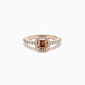 The Espresso 14K Rose Gold Brown and White Diamond Ring showcases a cushion-cut brown center stone, surrounded by a halo of white diamonds with extra diamonds adorning the band.
