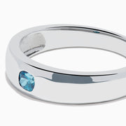 The Men's 14K White Gold Blue Diamond Ring showcases a single round blue diamond set into a sleek white gold band, shown on a plain white background.