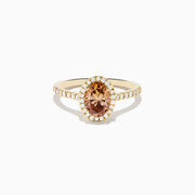 The Espresso 14K Yellow Gold Brown Diamond Halo Ring showcases an oval brown diamond center, encircled by a halo of white diamonds with additional diamonds set along the band.