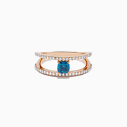 The Bella Bleu 14K Rose Gold Blue and White Diamond Ring features two parallel, diamond-encrusted bands and a cushion-cut blue gemstone centerpiece. This modern, elegant ring stands out beautifully against a crisp white background.
