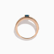 The Bella Bleu 14K Rose Gold Blue and White Diamond Ring features two parallel, diamond-encrusted bands and a cushion-cut blue gemstone centerpiece. This modern, elegant ring stands out beautifully against a crisp white background.