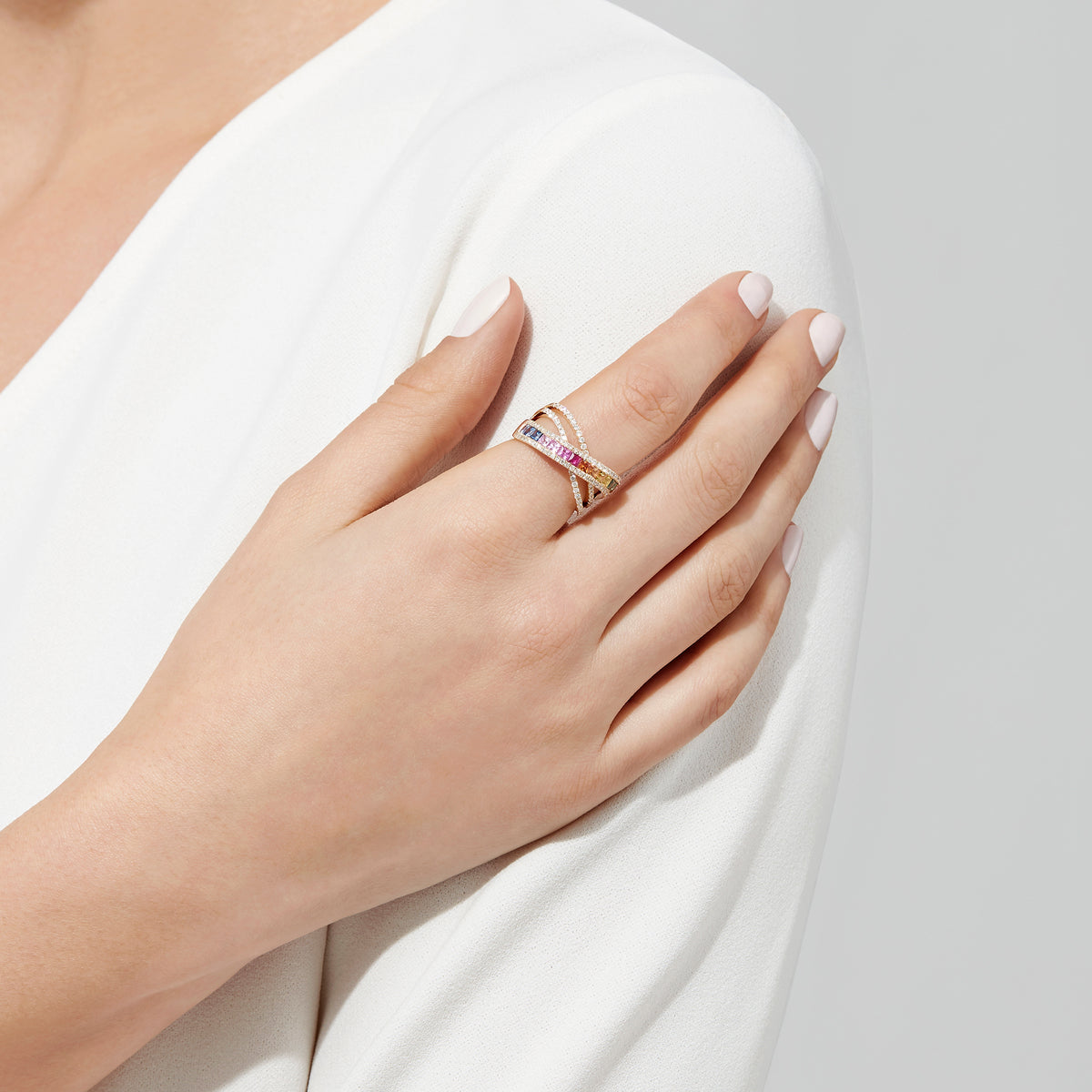 The Watercolors 14K Yellow Gold Multi Sapphire and Diamond Ring (2.05 TCW) showcases a crisscross design with two rows of diamonds and a central row of vibrant, square-cut multi-colored sapphires.