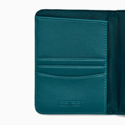 Teal Vegan Leather Passport Holder open to display card slots on the left, a transparent ID section in the center, and a larger pocket on the right, all crafted from vegan leather against a white background.