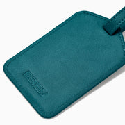 A teal Vegan Leather Luggage Tag with a rectangular clear window and an adjustable strap with gold buckle, shown on a white background.