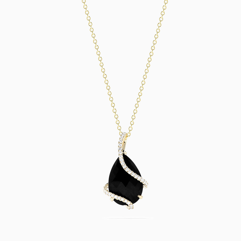 The Eclipse 14K Yellow Gold Onyx and Diamond Pendant, 6.29 TCW, showcases a large faceted onyx teardrop wrapped with a delicate band of sparkling diamonds on a gold chain.