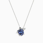 The Seaside 925 Sterling Silver Multi Diamond and Tanzanite Turtle Pendant features a turtle-shaped design with tanzanite gemstones on its shell and clear stones on one flipper, shown against a white background.