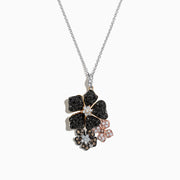 A Nature 14K Tri Color Gold Diamond Hibiscus Pendant (1.36 TCW) on a silver chain, with three jeweled flowers—two black with white centers and one smaller pink with a white center—set against a white background.
