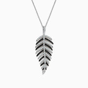 A 14K white gold pendant with .89 TCW black and white diamonds, arranged along leaf-shaped veins, hangs from a thin chain—reminiscent of Effy’s style—shown against a white background.