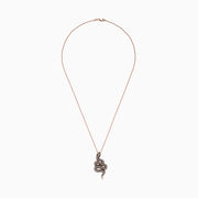 The Safari 14K Rose Gold Diamond and Tsavorite Snake Pendant (1.41 TCW) features a coiled serpent design with diamond and tsavorite eyes, black and white gems along its body, all on a delicate chain.