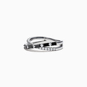 The 14K White Gold Black and White Diamond Crossover Ring, 0.77 TCW, features two intertwined bands with alternating black and white diamonds, displayed on a white background.