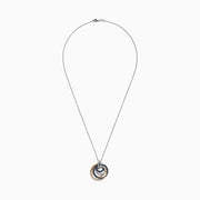 The Royale Bleu 14K 2-Tone Sapphire and Diamond Circles Pendant (1.09 TCW) features interlocking textured circles in gold and silver, encrusted with sapphires and diamonds, elegantly hanging from a delicate silver chain.
