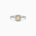 The Canare 18K Two-Tone Gold Cushion Halo Yellow Diamond Ring features a 0.61 TCW square yellow diamond center, surrounded by a halo of clear diamonds and additional diamonds on the band.