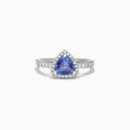 The Nahla Siri 14K White Gold Trillion Tanzanite and Diamond Ring, 0.96 TCW, showcases a triangular blue tanzanite center with a halo and band of sparkling white diamonds, presented on a white background.