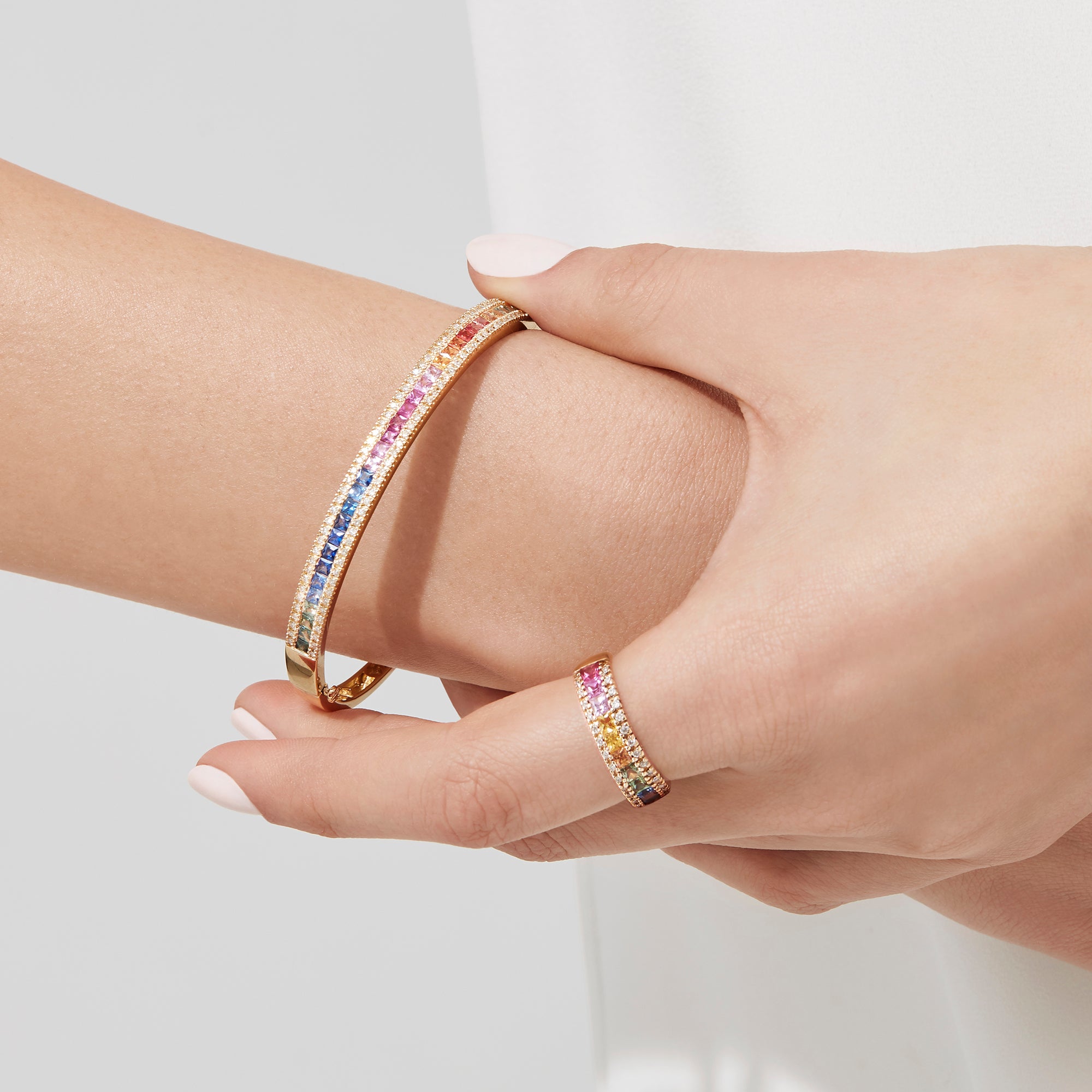 The Watercolors 14K Yellow Gold Multi Sapphire & Diamond Bangle (3.60 TCW) features a vivid gradient of green, yellow, orange, pink, and blue sapphires set in gold, shown against a white background.