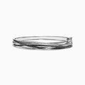 The 14K White Gold Black and White Diamond Bangle, 1.26 TCW, features multiple overlapping bands with sparkling black and white diamonds for a layered, textured look.