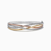 The Trio 14K Tri-Color Gold Diamond Crossover Bangle, 1.03 TCW, features intertwined bands of yellow, rose, and white gold accented with sparkling diamonds for an elegant and striking effect.