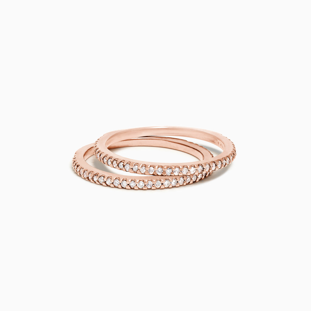 A set of two 14K rose gold bands—one pave diamond and one plain—are stacked together on a white background.
