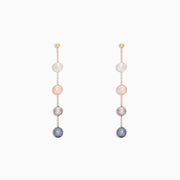 The 14K Yellow Gold Multi Color Cultured Pearl Earrings feature three vertically set cultured pearls in white, pink, and grey-blue hues on a delicate yellow gold chain, shown against a white background.