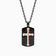 The Mens Rhodium Sterling Silver and Rose Gold Plated Cross Pendant features a black dog tag with a raised rose gold cross at the center, on a black chain, displayed against a white background.