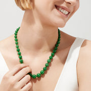 A close-up of a 14K Yellow Gold Jade Necklace, 339.00 TW, arranged in a curved shape against a white background.