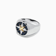 A mens sterling silver and 18K yellow gold ring features a gold star center, encircled by blue sapphires (0.75 TCW) in a striking pattern on top.