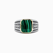 The Mens Sterling Silver and 14K Yellow Gold Malachite Ring, 6.05 TCW, features an intricate geometric pattern and a rectangular green malachite stone set in a yellow gold bezel, shown on a plain white background.