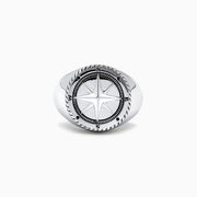 The Mens Sterling Silver Compass Ring showcases a detailed star at the center and engraved directional markers (N, E, S, W) around the edge. Its striking design is highlighted against a plain white background.
