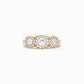 The Bouquet 14K Yellow Gold Three-Stone Diamond Halo Ring, 1.01 TCW, showcases three round diamonds with sparkling halos set in a thick gold band, displayed on a plain white background.