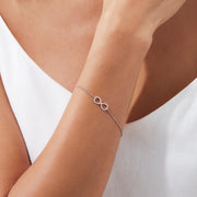 The Novelty 14K White Gold Diamond Infinity Bracelet, 0.12 TCW, features a sparkling infinity symbol on a delicate chain with clasp closure and three adjustable loops for an ideal fit.