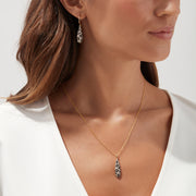 These 14K yellow gold drop earrings feature teardrop pendants with an intricate espresso, black, and white diamond design, totaling 1.26 TCW.