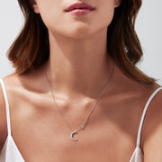 A Novelty 14K White Gold Diamond Crescent & Star Necklace (0.09 TCW) features a crescent moon pendant with sparkling diamonds and a separate star charm on a fine chain, shown against a white background.