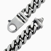 The Mens 925 Sterling Silver Chain Link Bracelet features thick Cuban links and a secure box clasp, displayed in a circular shape on a white background.