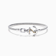 The Seaside Sterling Silver & 18K Gold Anchor Bangle features a twisted cable design, an anchor-shaped clasp, and rope detail for a nautical touch, showcased on a white background.
