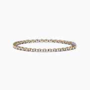The 14K Two Tone Gold Yellow and White Diamond Tennis Bracelet, 4.30 TCW, features a continuous row of sparkling diamonds in alternating yellow and white gold links, displayed against a white background.