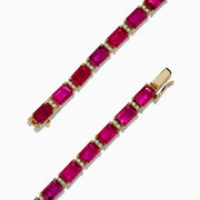 A 14K yellow gold bracelet set with rubies and diamonds, totaling 14.97 TCW, arranged in an elegant tennis style.