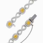The Canare 14K Two Tone Gold Yellow and White Diamond Infinity Tennis Bracelet, 3.34 TCW, features an intricate infinity pattern set with yellow gemstones framed by diamonds and a secure right-side clasp.