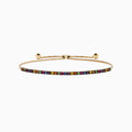 The Watercolors 14K Yellow Gold Tsavorite and Multi Sapphire Tennis Bracelet features closely set vibrant gemstones along an adjustable gold band, showcased on a white background.