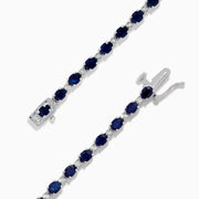 The 925 Sterling Silver Blue Sapphire Tennis Bracelet features a continuous row of oval blue sapphires set in prongs with a secure clasp.