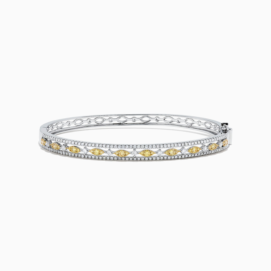 The Canare 14K White Gold Yellow and White Diamond Bangle, 1.27 TCW, features a stunning row of yellow and white diamonds in an intricate center design, elegantly showcased on a white background.