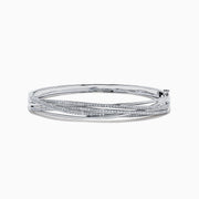 The 14K White Gold Diamond Cross Over Bangle, 1.05 TCW, features intertwined bands with dazzling diamonds, beautifully displayed on a white background.