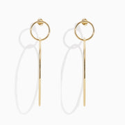 A pair of 14K Yellow Gold Double Circle Drop Earrings, one shown from the side and the other from the front, both displaying minimalist circular designs against a white background.