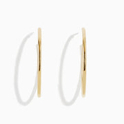 The 14K Yellow Gold Round Tube Open Hoop Earrings are shown on a white background—one upright to highlight the circular design, the other laid flat to showcase thickness and clasp detail.