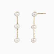 The 14K Yellow Gold Cultured Fresh Water Pearl Drop Earrings feature three round pearls on each earring, linked by delicate gold chains and shown against a white background.