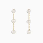 The 14K Yellow Gold Cultured Fresh Water Pearl Drop Earrings feature three round pearls on each earring, linked by delicate gold chains and shown against a white background.
