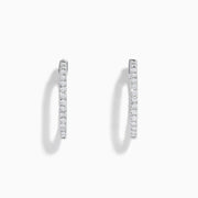 A pair of 14K White Gold 3/4 Diamond Hoop Earrings, thin and encrusted with sparkling diamonds, displayed vertically on a white background with soft shadows.